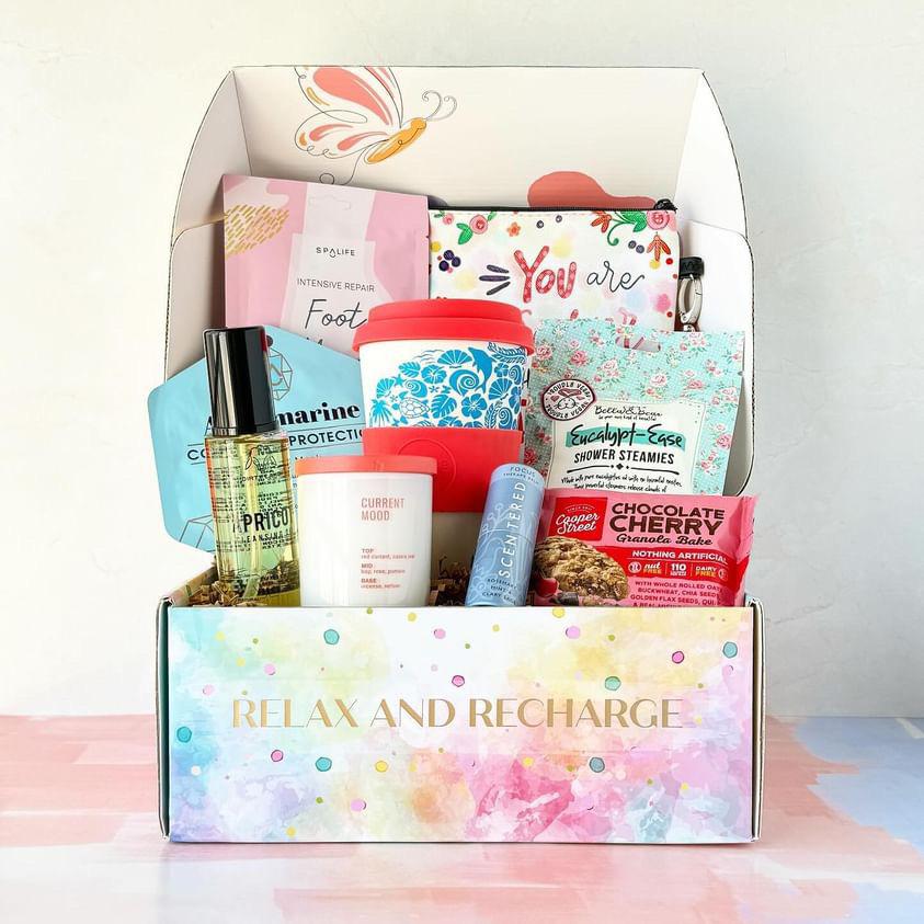 A past GenGlow Box filled with skincare, a reusable cup and shower steamies
